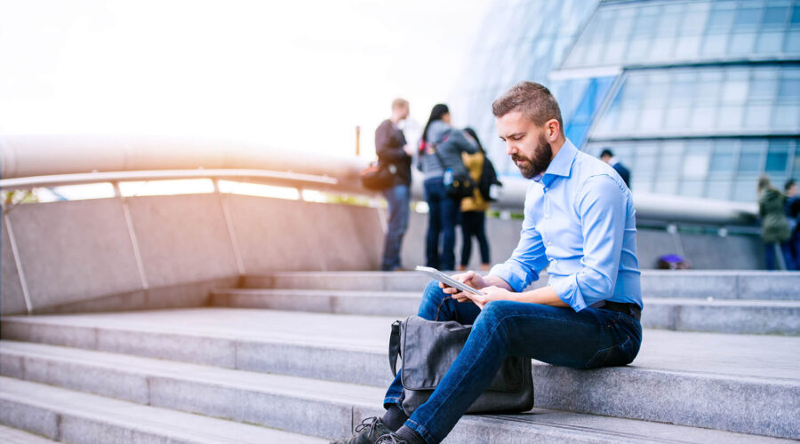 manager-with-tablet-sitting-on-stairs-london-city-PGB92TN manager-with-tablet-sitting-on-stairs-london-city-PGB92TN